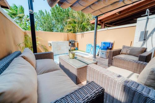 a patio with a couch and chairs and a table at Gold coast beautiful house with private pool in Palm-Eagle Beach