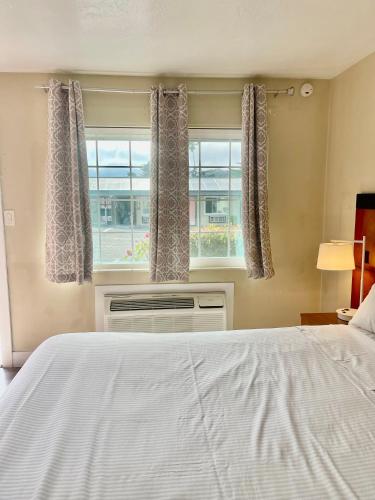 a bedroom with a white bed and a window at Monterey Fairgrounds Inn in Monterey
