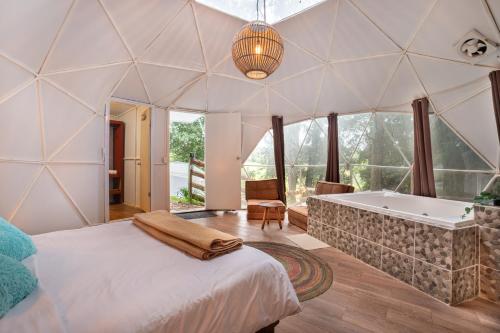 a master bedroom with a tub and a bed at Glamping-Zingo in Santa Ana Jilotzingo