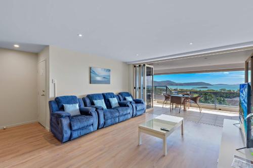 a living room with a blue couch and a table at Getaway Ocean Views KIDS STAY FREE in Airlie Beach