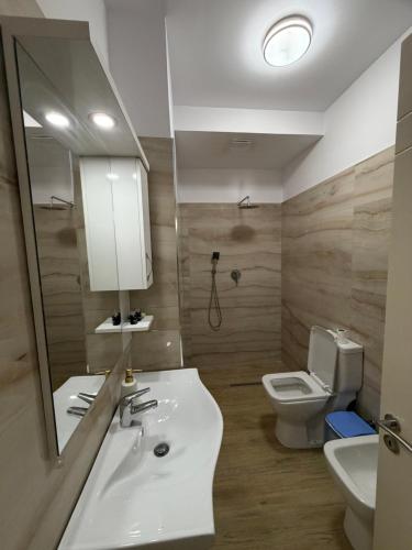 a bathroom with a sink and a toilet and a mirror at Mateo Apartaments in Vlorë