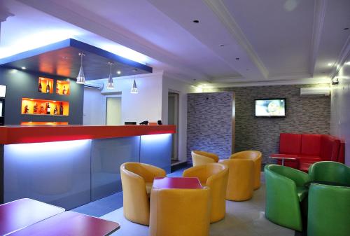 a restaurant with colorful chairs and a bar at KSF Place Alaka in Lagos