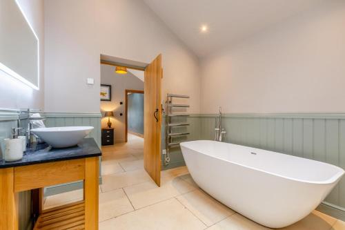 a bathroom with a large white tub and a sink at 2 Bed in Leyburn oc-g0099 in Constable Burton