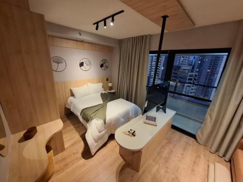 a hotel room with a bed and a window at SKY design Alphaville by Rhouses in Barueri