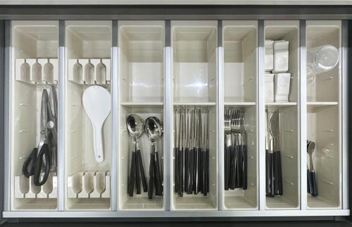 a cabinet with silver utensils in it at Brown Suites Busan Station in Busan