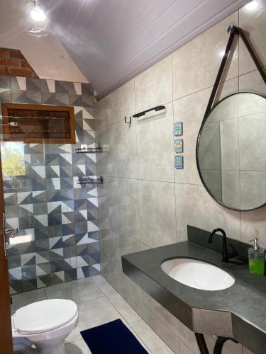 a bathroom with a sink and a mirror at Pousada do Chicó in São Roque de Minas