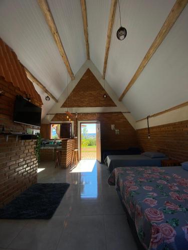 a room with a bed and a living room at Pousada do Chicó in São Roque de Minas