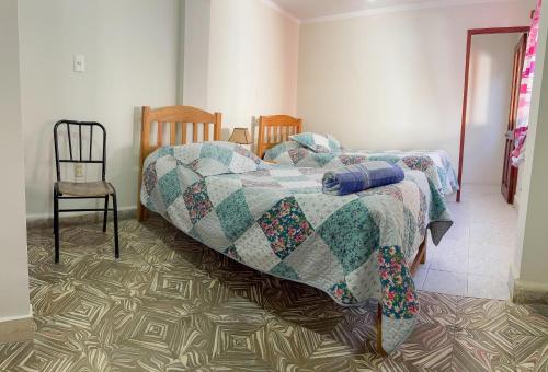 a bedroom with two beds and a chair at Tango in Sucre