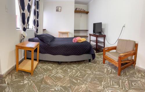 a bedroom with a bed and a chair at Tango in Sucre
