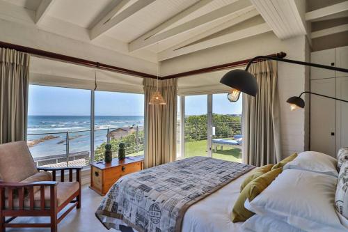 a bedroom with a bed and a view of the ocean at Vinho Verde Splendid Sea View Jacuzzi in Franskraalstrand