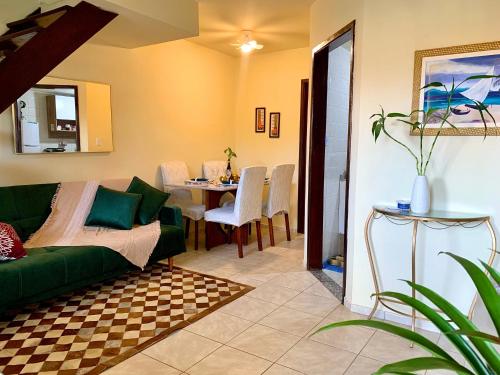 a living room with a green couch and a table at Casa à Beira Mar em Praia Seca Araruama RJ in Araruama