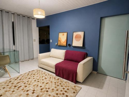 a living room with a chair and a couch at Apartamento em localização estratégica em Aracaju in Aracaju