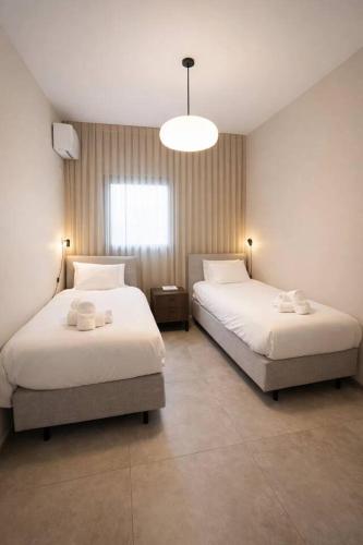 a bedroom with two beds and a light fixture at 2 Br Apartment In Savyoney Tower W Room in Jerusalem