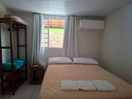a bedroom with a bed with two towels on it at Casinha Virtuosa in Monte Sião