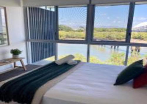 a bedroom with a large bed with a large window at Nature Meets City on Mint in Townsville