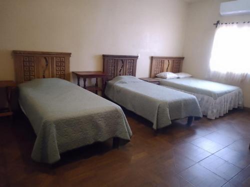 a room with two beds and a window at Posada la istmeña in Salina Cruz