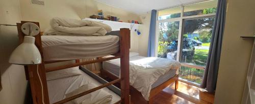 a room with two bunk beds and a window at Serendip in Point Lonsdale