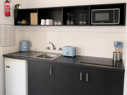 a kitchen counter with a sink and a microwave at BIG4 Robe Lakeside Tourist Park in Robe