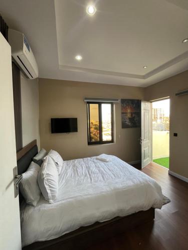 a bedroom with a large white bed and a window at Pcg Homes in Lagos