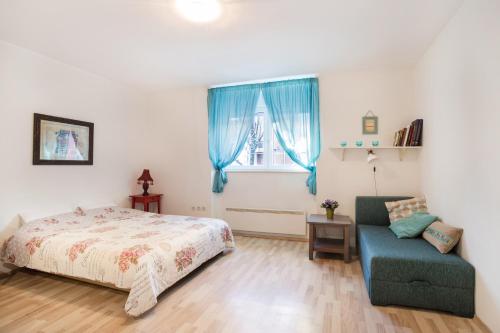 a bedroom with a bed and a chair and a window at Apartment Roza in Zagreb