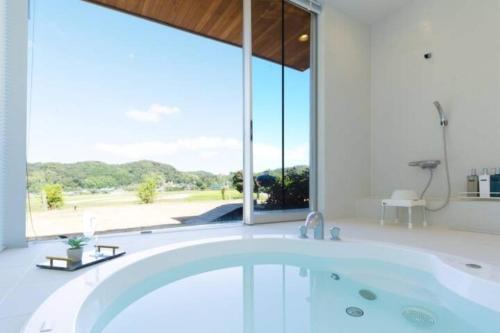 a bath tub in a bathroom with a large window at The SATOYAMA HILLS FK1 in Futtsu