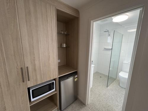 a bathroom with a toilet and a television in it at Frewville Motor Inn in Adelaide