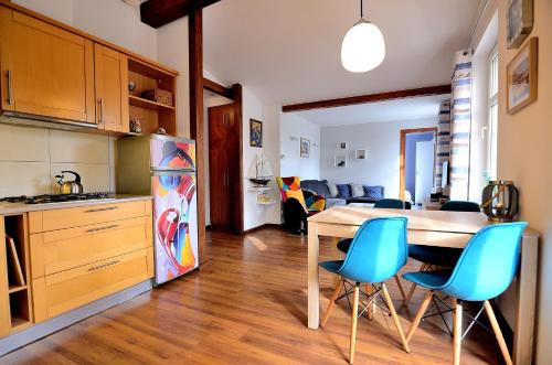 ソポトにあるVictus Apartamenty, Apartament Nemoのキッチン、ダイニングルーム(テーブル、青い椅子付)