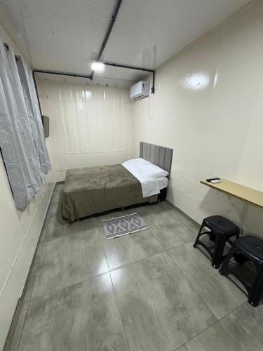 a room with a bed and a desk in it at Contêineres em Bombinhas in Bombinhas