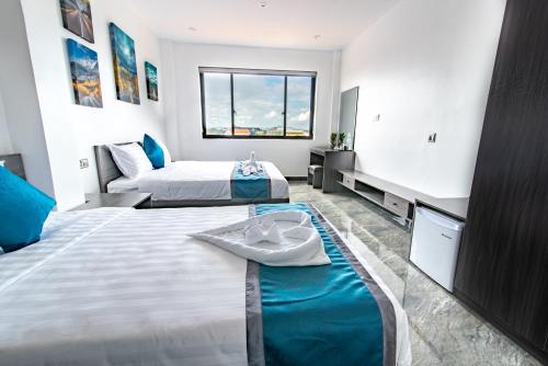 a hotel room with two beds and a window at A&J Kampot Boutique in Kampot