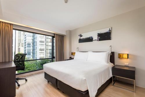 a hotel room with a bed and a large window at Maitria Hotel Sukhumvit 18 Bangkok – A Chatrium Collection in Bangkok