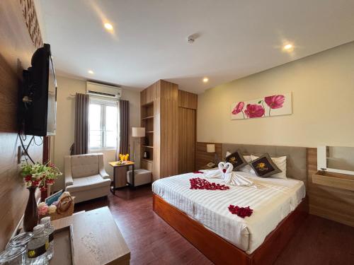 a hotel room with a bed with red flowers on it at Sen Vàng Luxury Hotel in Nha Trang