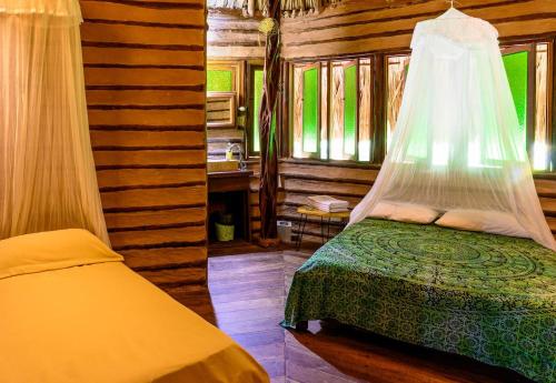 a bedroom with a bed with a mosquito net at 3 Cozy TripleDouble Rooms - Trisquel in Restrepo