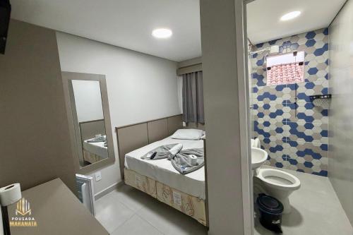a small bathroom with a bed and a sink at Pousada Maranata in Aparecida