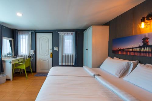 a bedroom with two beds and a desk in it at BB House Phra Athit บีบี เฮ้าส์ พระอาทิตย์ in Bangkok