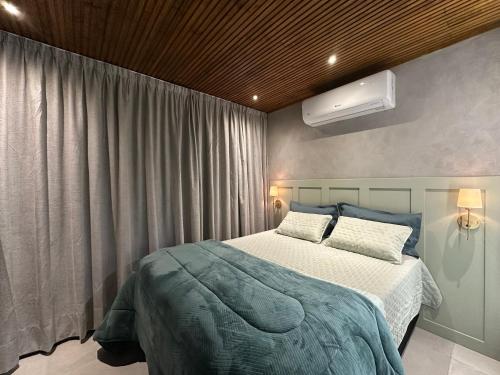 a bedroom with a large bed and a window at Altos do Perito Cabanas in Alfredo Wagner