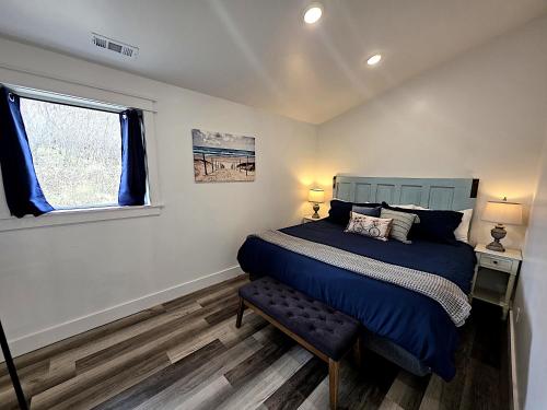 a bedroom with a blue bed and a window at Bluff Hideaway - Guest House in Homer