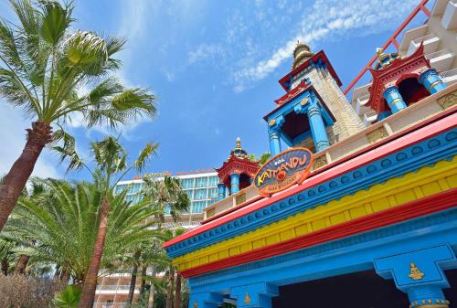 a colorful building in front of a hotel with palm trees at SOL by Meliá Katmandú Park and Resort in Magaluf
