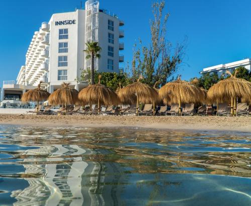 a group of straw huts on the beach at INNSiDE by Meliá Ibiza Beach in San Antonio Bay