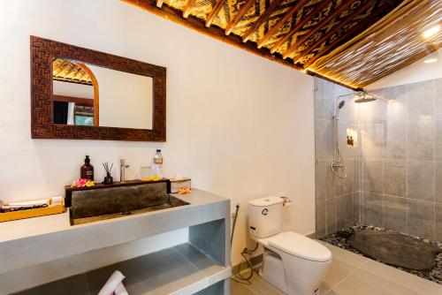 a bathroom with a sink and a toilet and a shower at Uma Harum Sari by Dhananjaya Hospitality in Penginyahan