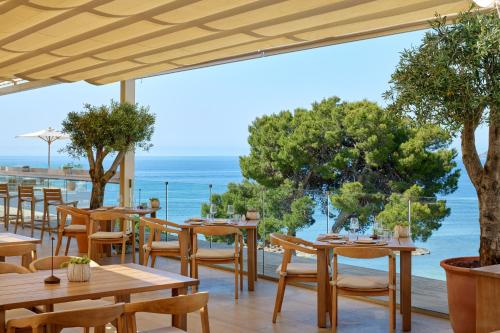 a restaurant with tables and chairs and a view of the ocean at ME by Meliá Ibiza - The Leading Hotels of the World in Santa Eularia des Riu