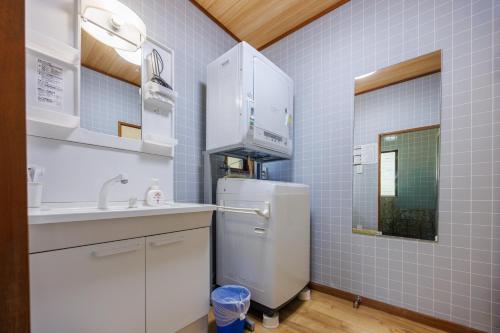 a small kitchen with a refrigerator and a sink at ネバーランド伊豆 Neverland IZU in Ito