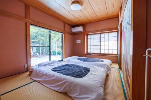 two beds in a room with a window at ネバーランド伊豆 Neverland IZU in Ito