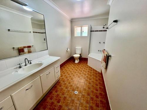 a bathroom with a sink and a toilet and a mirror at Riverside Boulevard 13-151 close to HOSPITAL in Ross River