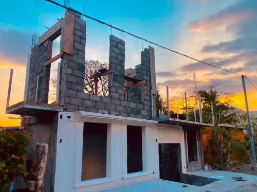 a house under construction with a sunset in the background at Casa Hostal Samaria in Altagracia