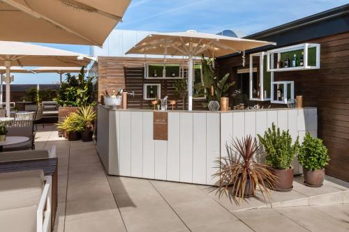 an outdoor bar with an umbrella and some plants at Meliá Madrid Serrano in Madrid