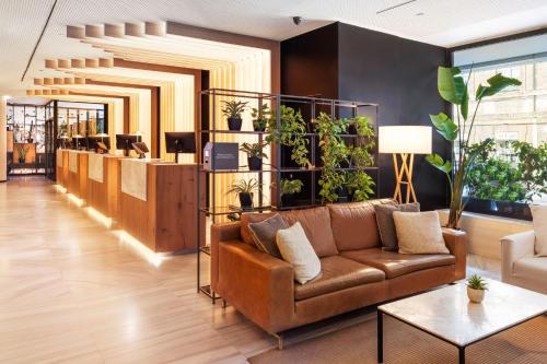 a lobby with a couch and plants on the wall at Meliá Madrid Serrano in Madrid