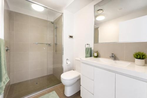 a bathroom with a toilet and a sink and a shower at Harbourfront Views at Allure 2 Bedroom Apartment in Townsville