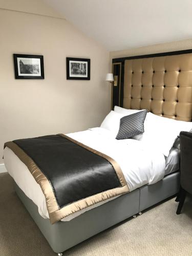 a bedroom with a large bed with a large headboard at Museum Residence Oxford in Oxford