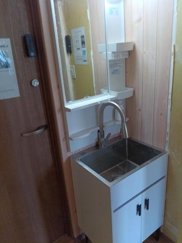 a bathroom with a sink and a mirror at YCS2 Guest house, good access to Shinjuku in Nishitokyo