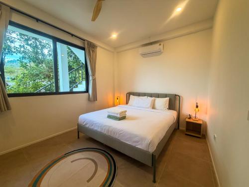 a bedroom with a bed and a large window at v15 Ocean Serenity Residence in Ko Phangan
